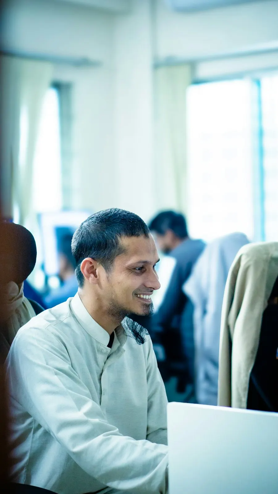 A smiling man working at his desk