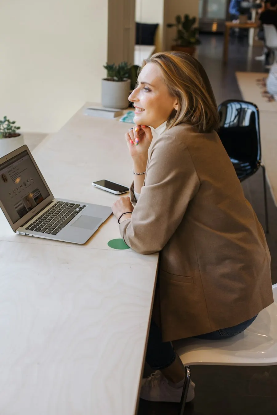 A woman working on a laptop at her desk